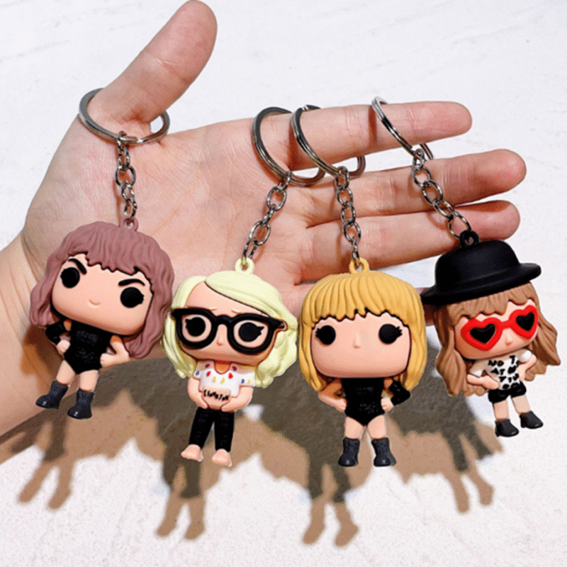 Taylor Swift Silicone Keychain Set in stylish purple packaging with 4 unique designs, featuring musical motifs and fan-inspired figures.