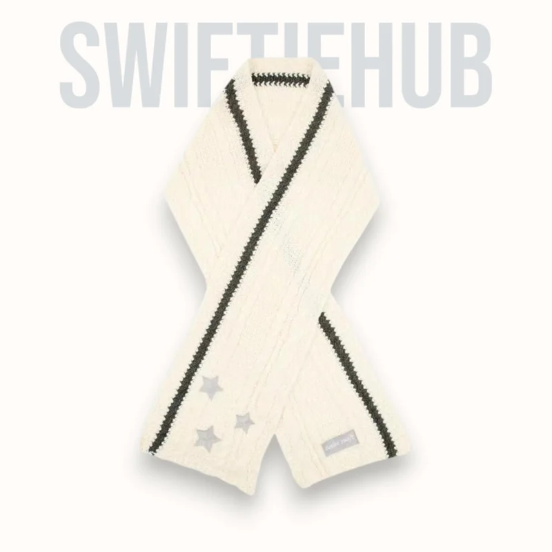 Cream cable knit scarf with grey stripes and star embroidery folded neatly.